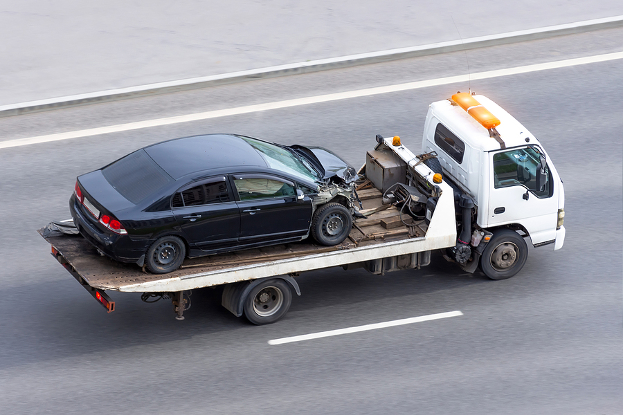 Wrecked Car After An Accident On A Tow Truck Transported On A Hi